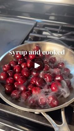 a frying pan filled with cherries cooking on the stove