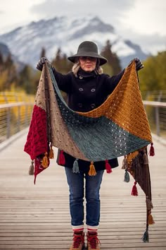 a woman is standing on a bridge with her scarf