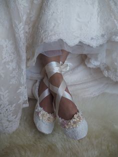 a bride's shoes and wedding dress on her feet