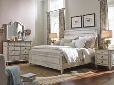 a bedroom scene with focus on the bed, dresser and mirror in the room's center