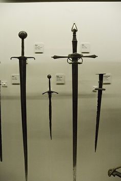 several swords are on display in a museum