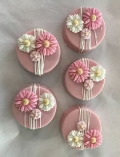 four pink and white flowers are on top of each other in the shape of buttons