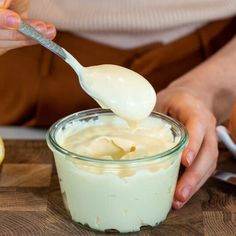 a person is spooning mayonnaise into a bowl