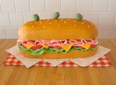 a large sandwich cake sitting on top of a wooden table