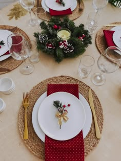 a table set for christmas dinner with place settings