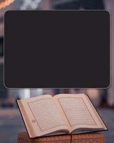 an open book sitting on top of a wooden block in the middle of a street