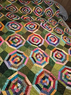 a bed with a colorful quilt on top of it