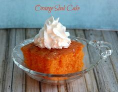 orange souffle cake with whipped cream in a glass bowl on a wooden table