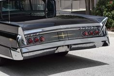 an old black car is parked on the street