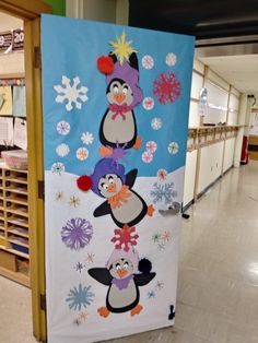 a bulletin board with penguins and snowflakes on it in a store hallway,