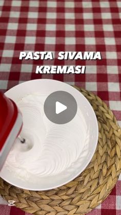 a red and white checkered table cloth with a bowl on top of a plate