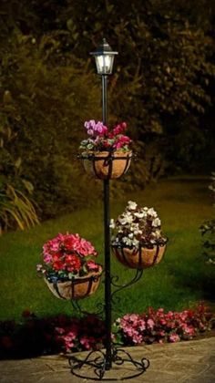 three flower pots are hanging from a lamp post