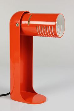 an orange table lamp on a white surface