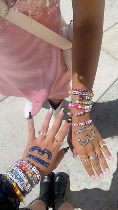 two girls with their hands covered in bracelets