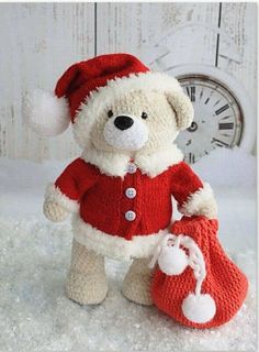 a teddy bear wearing a red sweater and hat with a bag in front of it