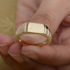 a person holding a gold ring in their hand