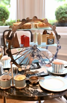 a table topped with plates and cups filled with desserts next to a ferris wheel