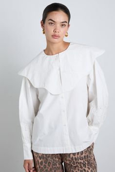 The Romeo is a hip length shirt with full, cuffed sleeves and a rounded neckline. It features an oversized wave edge collar with "DM" Damson Madder broderie detailing along the collar edge and arm. •100% Organic Cotton •Oversized collar •White embroidery detailing •We recommend sizing down for a neater fit MODEL INFO: Sofie is 5'10 and is wearing a UK 10.