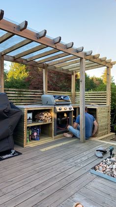 a man is fixing an outdoor bbq grill on a deck with wood planks