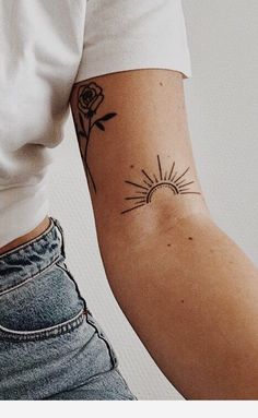 a woman's arm with a tattoo on it that has a sun and flowers