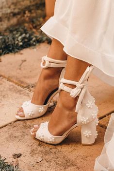 the bride's shoes are adorned with pearls