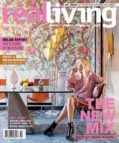 a woman sitting at a table in front of a wallpapered living magazine cover