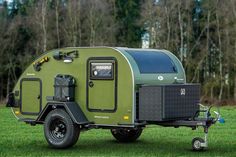 an off road camper trailer parked in the grass