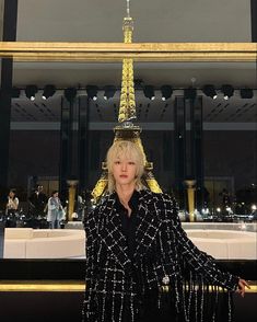 a woman standing in front of the eiffel tower