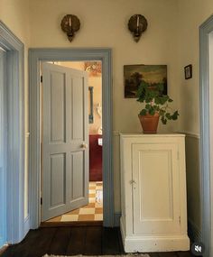 an open door leading to another room with a potted plant on top of it