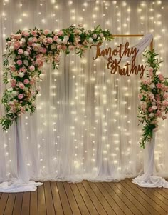 the wedding arch is decorated with pink flowers and greenery