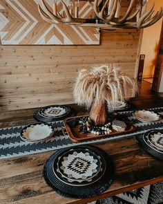 a table topped with plates and bowls on top of a wooden table covered in antlers