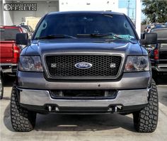 the front end of a silver truck parked in a parking lot