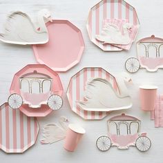 pink and white paper plates with swan carriage designs on them, along with cupcakes