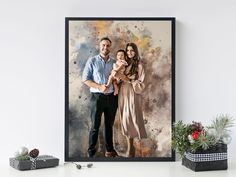 a man and woman holding a baby in front of a painting on the wall next to a potted plant