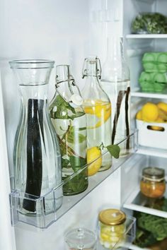 an open refrigerator filled with lots of different types of drinks and condiments in glass containers