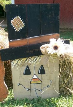 a wooden block with a scarecrow painted on it and a flower in the center