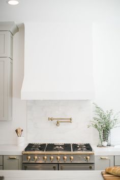 a stove top oven sitting inside of a kitchen next to a white counter and cabinets