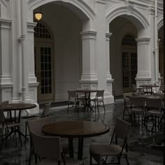 tables and chairs are lined up in an empty room with arches on either side of the building