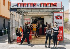 people standing in front of a taco stand