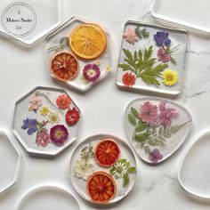 four plates with flowers and orange slices on them