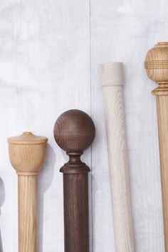 three wooden baseball bats lined up next to each other on a white wall with wood slats