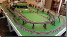 a model train set on display in a room with bookshelves and other items