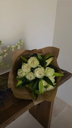 a bouquet of white flowers sitting on top of a wooden table