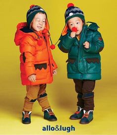 two young children standing next to each other wearing jackets and holding noses with their hands