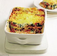 two white plates topped with lasagna casserole on top of a table