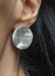 "Round silver earrings with a nice texture that looks like crumpled paper, which can be worn all day long, as they are very light to wear.   As they are modern and  elegant with beautiful satin finish and an original design  texture, these earrings are both flattering and feminine. DESCRIPTIONS and MEASUREMENTS: Material: sterling silver  Dimensions: 2,6*2,5 (cm)1,021*0,98\"(in). SEE MORE EARRINGS HERE: www.etsy.com/shop/ArtisJewels?ref=seller-platform-mcnav§ion_id§ion_id=35805426 Visit my Etsy shop, ArtisJewels, to see more earrings and jewelry and other unique handmade pieces. www.etsy.com/shop/ArtisJewels Do not hesitate to contact me for any questions about my jewelry. Any questions I would be happy to answer! ------------------------------------------------------ IMPORTANT We strongly Unique Silver Earrings, Modern Silver Round Earrings, Silver Diamond-cut Round Earrings, Artistic Silver Round Earrings, Modern Nickel-free Round Disc Earrings, Silver Nickel-free Round Disc Earrings, Big Stud Earrings, Design Texture, Crumpled Paper