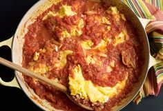 an omelet with eggs and tomato sauce in a pan