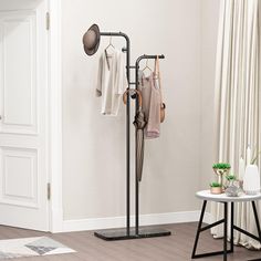 a coat rack with two umbrellas hanging from it's sides in a living room