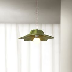 a green lamp hanging from a ceiling in a room