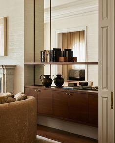 a living room filled with furniture and a fire place under a large mirror on top of a wall